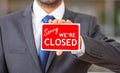 Man holding a sorry we are closed sign Royalty Free Stock Photo