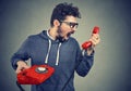 Man holding red telephone receiver and yelling in anger. Royalty Free Stock Photo