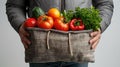 Man holding a reusable grocery bag full of fresh vegetables. eco-friendly shopping concept promoting health and