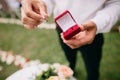 Man is holding a ring in his right hand and a red ring box in his left hand. Proposal concept Royalty Free Stock Photo