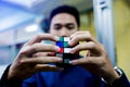 Man holding Rubik`s cube techincal and business solving problem