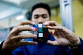 Man holding Rubik`s cube techincal and business solving problem