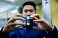 Man holding Rubik`s cube techincal and business solving problem