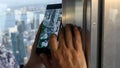 Man holding Samsung phone taking photo of the city from Tokyo Tower