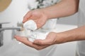 Man holding shaving foam in bathroom, closeup