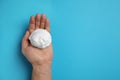 Man holding shaving foam on light blue, top view. Space for text