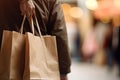 Man holding shopping bags in shopping mall, closeup. Space for text, Closeup rear view of a person holding shopping bag, AI