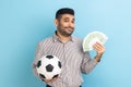 Man holding showing soccer ball and fun of hundred euro bills winning lot of money betting for sport Royalty Free Stock Photo