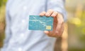 Man holding a simple blank empty plastic credit card or gift card in his hand, presenting it to the camera, copy space