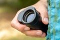 Man holding a simple magnifying monocular glass, modern spy spyglass in hand, object detail, closeup. Spying on someone, stalking