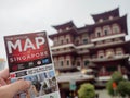 Man holding a Singapore map The back is Buddha Toothe Relic Temple in Chinatown Singapore Royalty Free Stock Photo