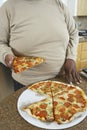 Man Holding Slice Of Pizza