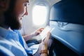 Man holding a smart phone with blank screen in airplane Royalty Free Stock Photo