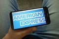 Man holding smartphone with American Express Company logo