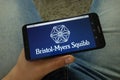 Man holding smartphone with Bristol-Myers Squibb Company BMS logo Royalty Free Stock Photo