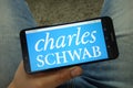 Man holding smartphone with Charles Schwab Corporation logo