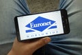 Man holding smartphone with Euronet Worldwide, Inc. company logo