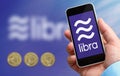 Man holding a smartphone in his hand with the libra logo, the new crypto currency created by facebook company Royalty Free Stock Photo