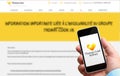 Man holding a smartphone in his hand with the Thomas Cook logo. Background of Blurry french homepage of the website indicating the