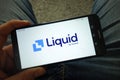 Man holding smartphone with Liquid cryptocurrency exchange logo