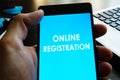 Man holding smart phone with online registration.