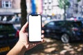 Man holding smartphone showing white blank screen at car parking Royalty Free Stock Photo