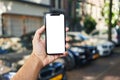 Man holding smartphone showing white blank screen at car parking Royalty Free Stock Photo