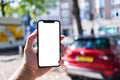 Man holding smartphone showing white blank screen at car parking Royalty Free Stock Photo