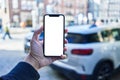 Man holding smartphone showing white blank screen at car parking Royalty Free Stock Photo