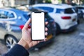 Man holding smartphone showing white blank screen at car parking Royalty Free Stock Photo