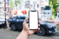 Man holding smartphone showing white blank screen at car parking Royalty Free Stock Photo