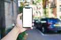 Man holding smartphone showing white blank screen at car parking Royalty Free Stock Photo