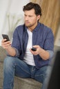 man holding smartphone and using app with remote control Royalty Free Stock Photo