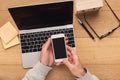 Man holding smartphone on vintage wooden table. Royalty Free Stock Photo