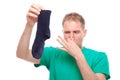 Man holding smelly socks and clogged nose Royalty Free Stock Photo