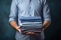 Man holding stack of clothes for reuse, donation or moving. Renewable concept, Laundry day, recycling, charity. Reuse, recycling