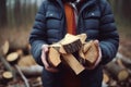 Man holding stack of cut firewood in forest. Generate ai