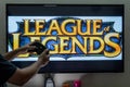 Man holding steam controller in front of a screen loading the popular RPG MMORPG league of legends a much loved popular