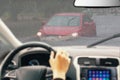 Man holding steering wheel, driving a car in the rain, careful driving in rainy day, left hand drive, close up. Flood