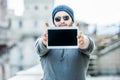 Man holding a tablet with both hands - urban blurred background