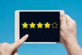 Man holding a tablet device and rating stars as evaluation, rank