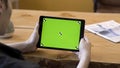 Man holding a tablet in his hands without motions, green screen with tracking marks. Stock footage. Male looking at his