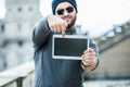 Man holding a tablet and pointing at the screen - blurred background