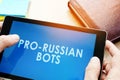 Man holding tablet with pro-russian bots. Russian internet propaganda concept. Royalty Free Stock Photo