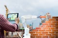 Man holding a tablet Remote control Smart robot industry 4. 0 arm brick building construction human force Royalty Free Stock Photo