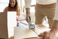 Man holding tape dispenser packing cardboard box on moving day Royalty Free Stock Photo