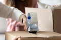 Man holding tape dispenser sealing cardboard boxes with belongings Royalty Free Stock Photo