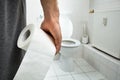 Man Holding Tissue Paper Roll Standing In Front Of Toilet Bowl Royalty Free Stock Photo