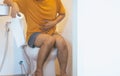 Man holding toilet paper and using toilet with suffering from Diarrhea and Hemorrhoids after wake up in morning at home