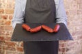 Man holding tray with 4 chorizos on Royalty Free Stock Photo